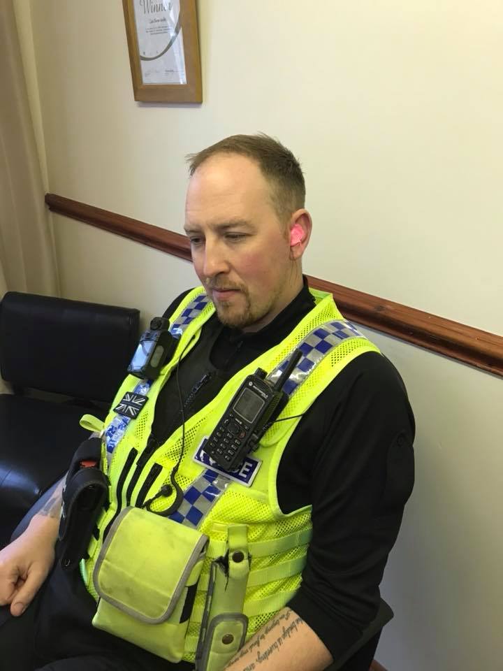 A Policeman having ear moulds taken